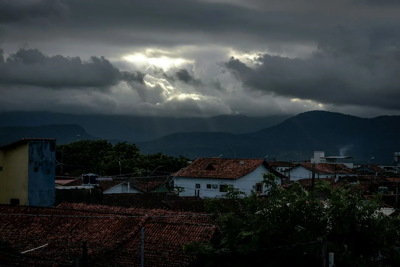 Storm clouds over hillside houses